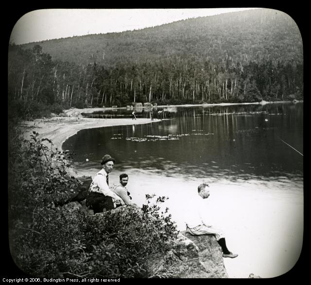 Men on Rocks Rifle Fire in Background